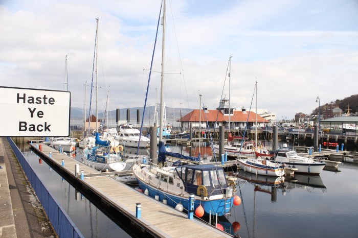 sign boats harbour blue skies