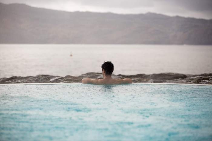 person in water looking at open body of water