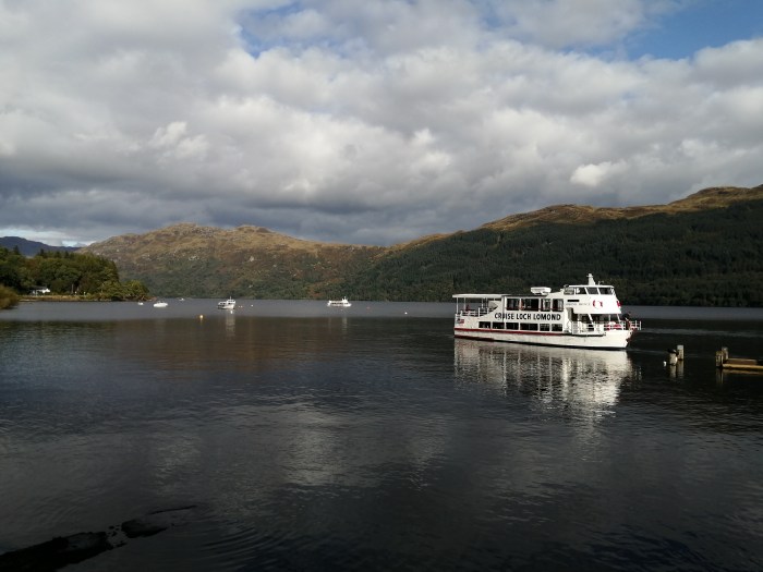 boat on open water hills clouds