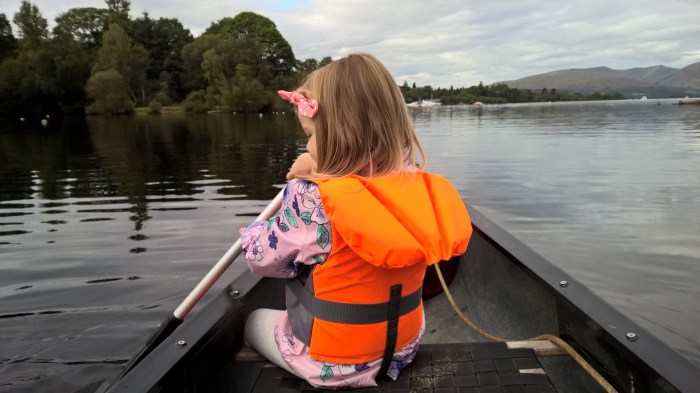 orange lifewest girl in pink open body of water