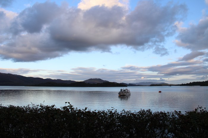 clouds open body of water boat dusk