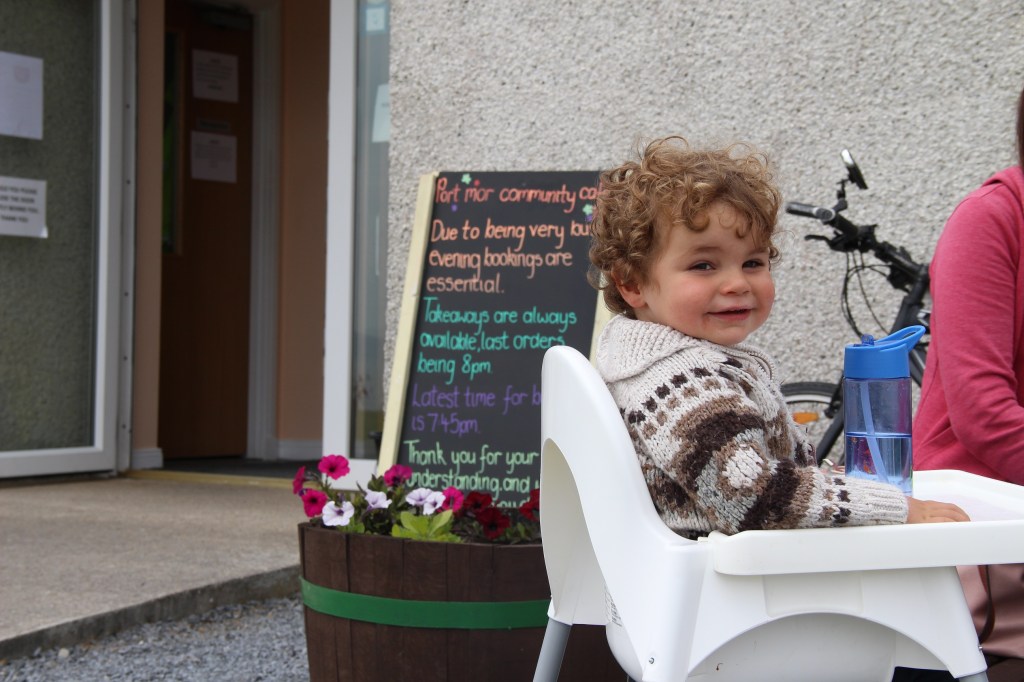 smiling boy, happy boy, restaurant sign, flowers, islay, scotland