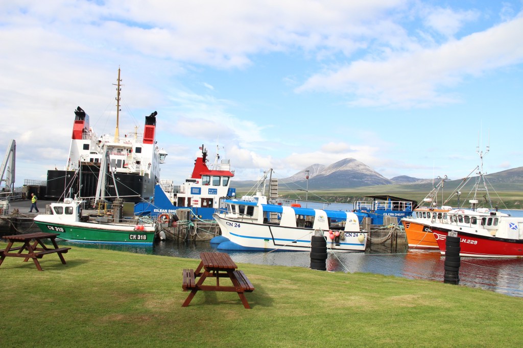 port askaig, boats, ferry, hills, blue skies, wooden bench, jura, islay, scotland