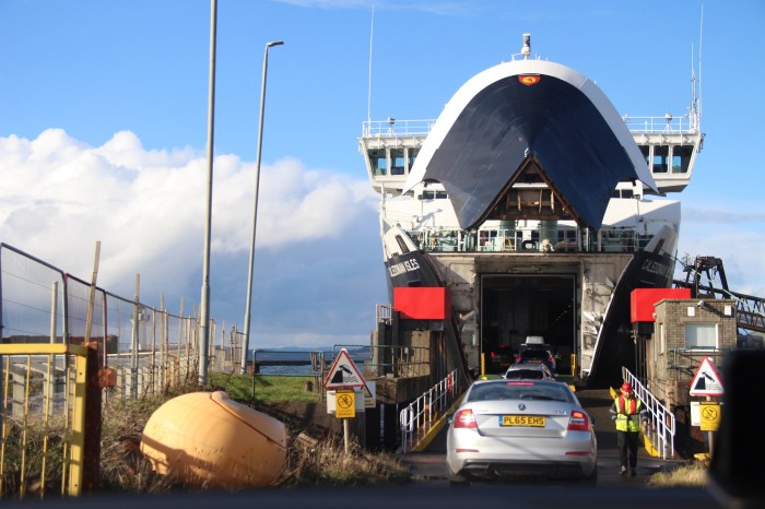 silver car, ferry, blue skies