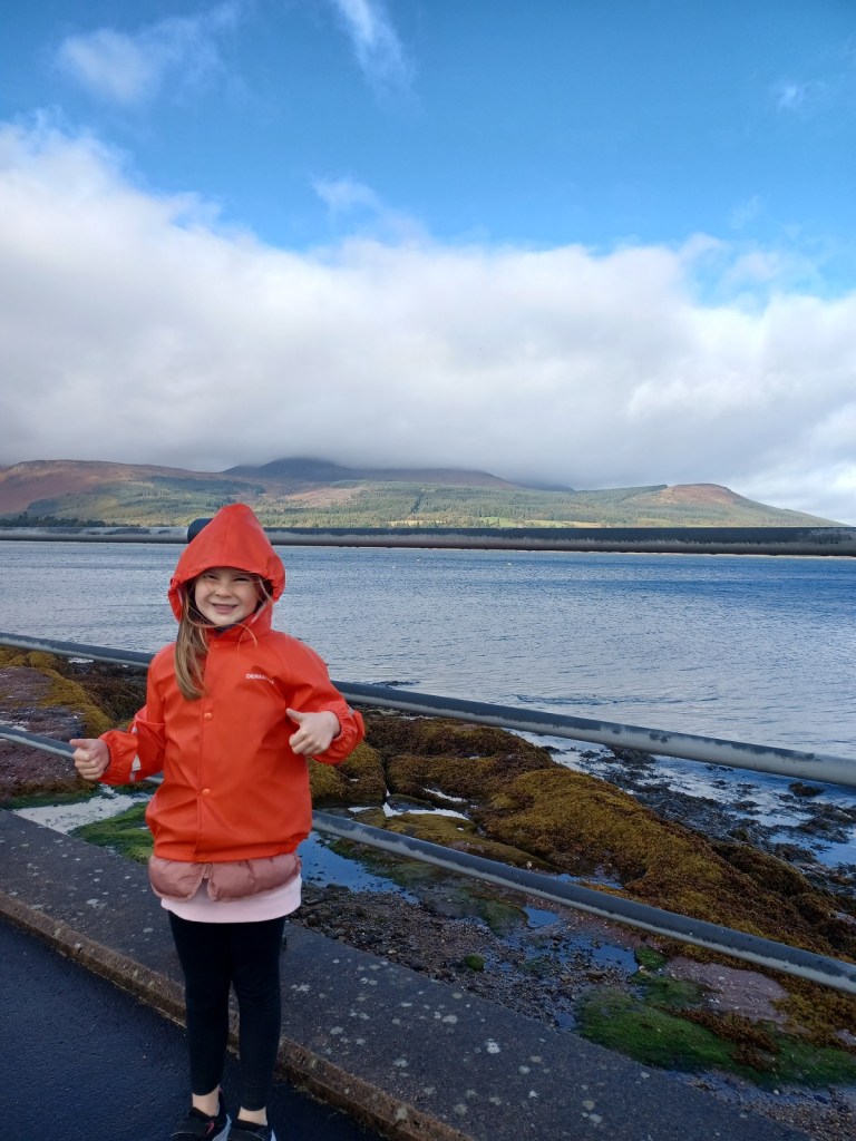 girl in raincoat, open water, goatfell hill, isle of arran, cloudy skies