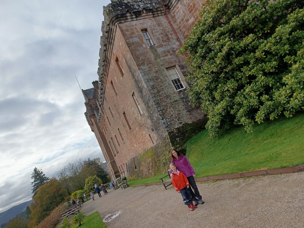 brodick castle, girl in waterproof, lady in waterproof, castle, cloudy skies